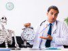 Young male doctor and skeleton patient