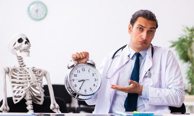 Young male doctor and skeleton patient