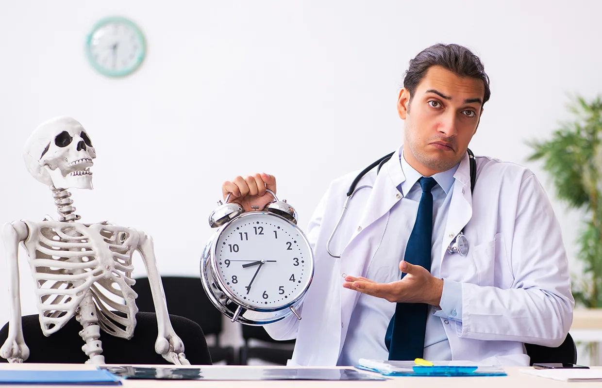 Young male doctor and skeleton patient