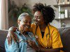 Smiling young female nurse caregiver assisting senior woman