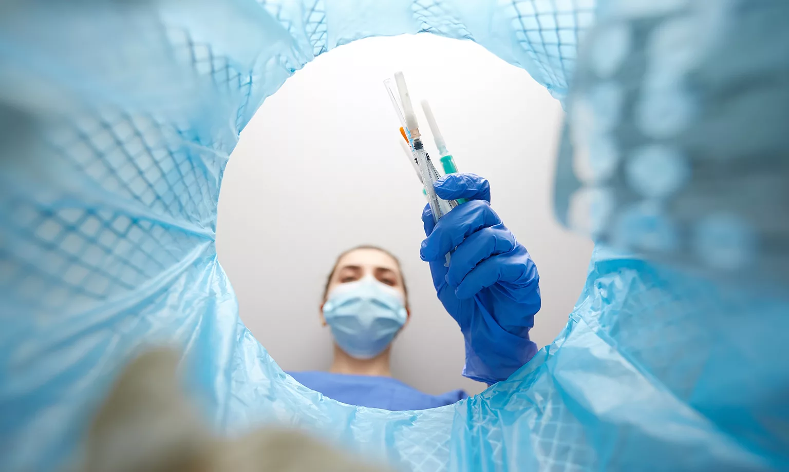 doctor throwing used syringes into trash can