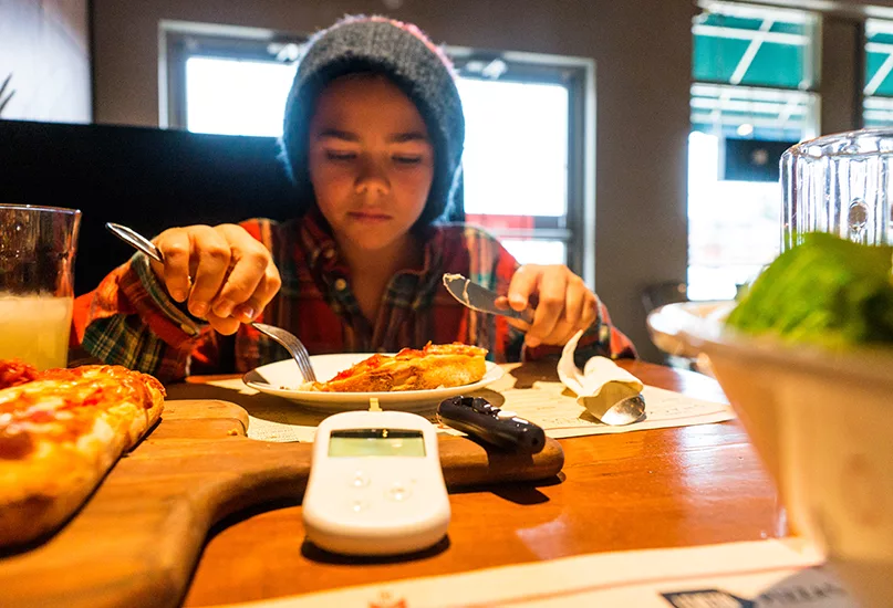 Child with diabetes in a restaurant eating