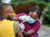 image of young nurse in face mask, injecting young patient