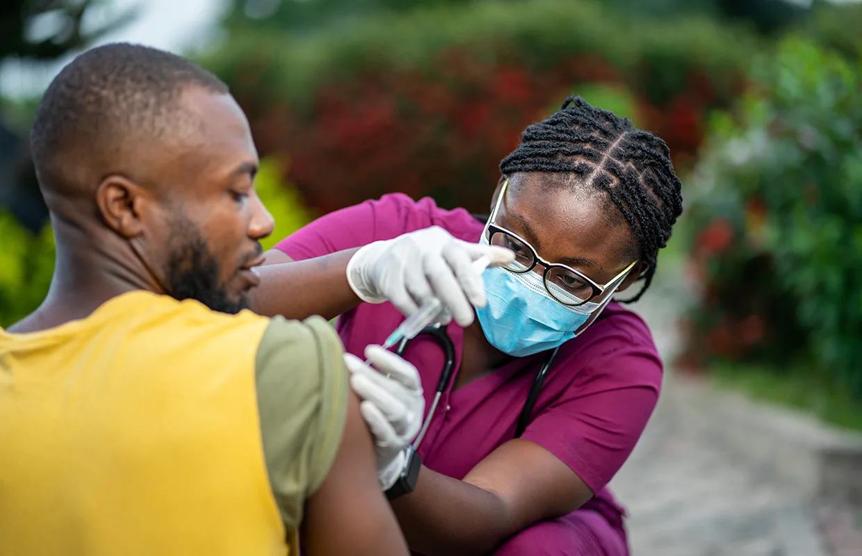 image of young nurse in face mask, injecting young patient